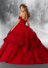 Load image into Gallery viewer, The back view of a young lady wearing a tiered ballgown with off-shoulder sleeves in the color red.
